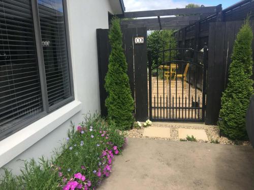 a black gate with flowers in front of a house at Private Retreat in Cambridge