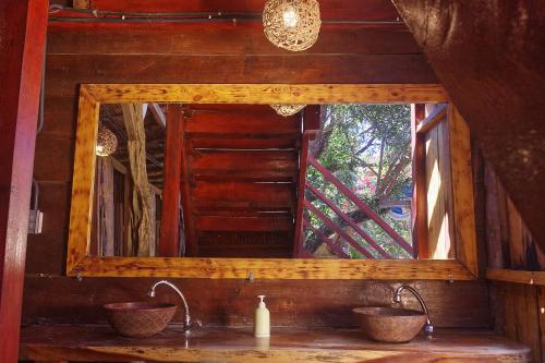 a mirror over a sink in a room at Casa Bambucha Hostel in Las Peñitas