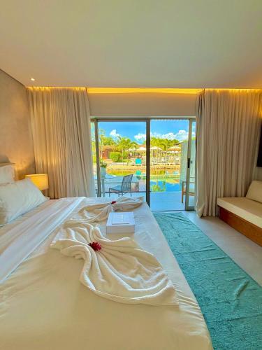 a bedroom with a bed with a book on it at Île Lumière in Pipa