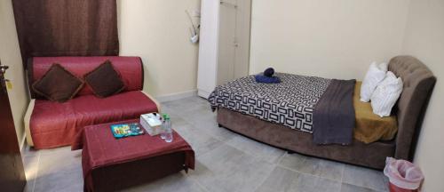 a room with a bed and a couch and a chair at Guest house in New kwaitat near Al Ain Mall in Al Ain