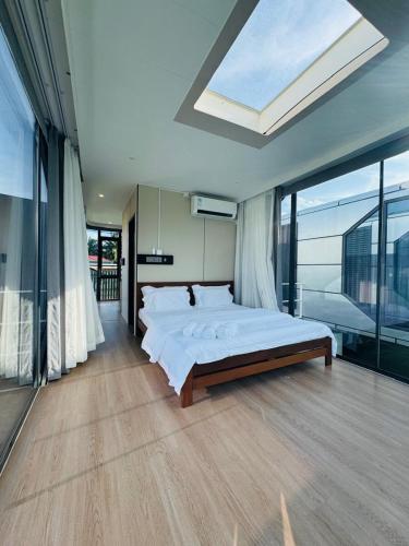 a bedroom with a large bed and a large window at Coolhomtel in Semporna