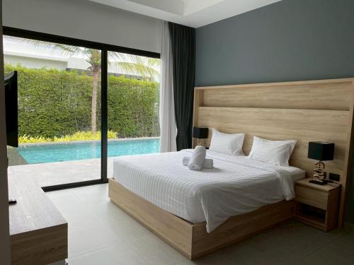 a bedroom with a large bed and a pool at Sivana HideAway Villas Hua-Hin in Khao Tao