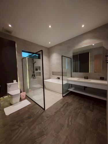 a bathroom with a tub and a toilet and a sink at Sivana HideAway Villas Hua-Hin in Khao Tao
