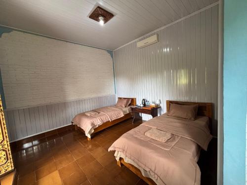 a bedroom with two beds in a room at Warsi Bungalow in Ubud