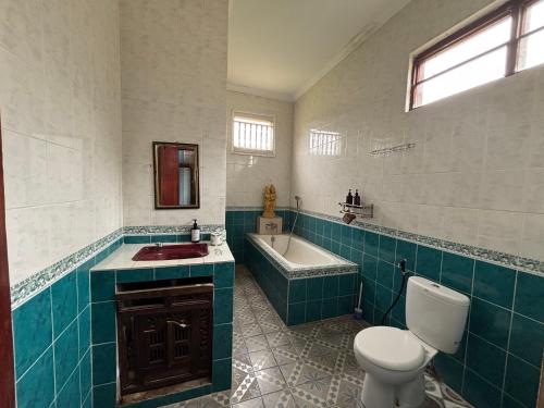 a bathroom with a toilet and a tub and a sink at Warsi Bungalow in Ubud