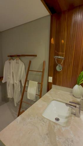 a bathroom with a sink and a towel rack at Île Lumière in Pipa