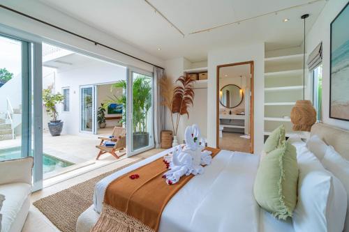 a bedroom with a large bed with an elephant toy on it at Villa Arlo Canggu in Canggu
