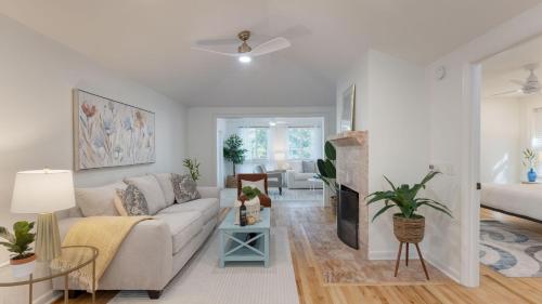 a living room with a couch and a tv at Conch Cottage by AvantStay Walk to Beach Deck Fireplace Outdoor Dining in Isle of Palms
