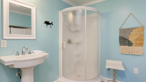 a bathroom with a shower and a sink at Conch Cottage by AvantStay Walk to Beach Deck Fireplace Outdoor Dining in Isle of Palms