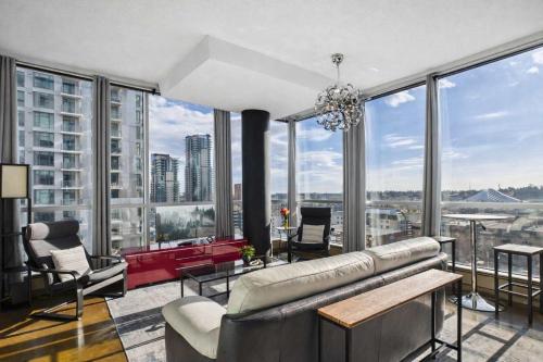 a living room with a couch and chairs and large windows at Modern Beltline Escape Sky-High Views DT Views in Calgary