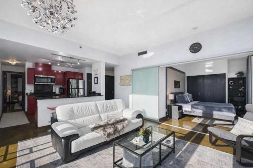a living room with a white couch and a table at Modern Beltline Escape Sky-High Views DT Views in Calgary