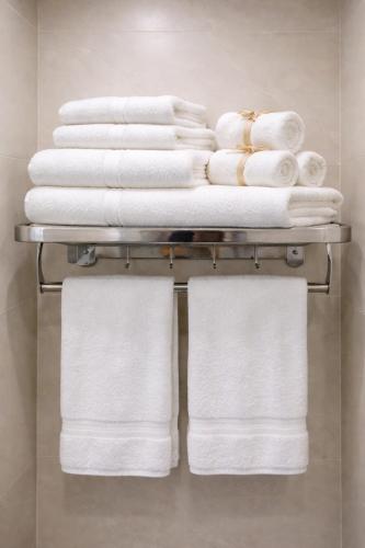 a stack of towels on a towel rack in a bathroom at Vũ Ngọc Hotel Núi Sam in Chau Doc