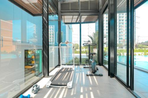 an indoor gym with treadmills and a swimming pool at Fourium Pattaya Hotel and Serviced Residence in Pattaya South