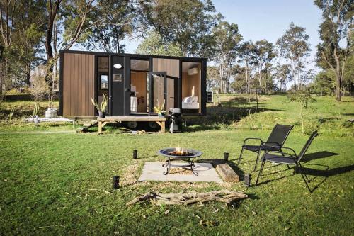 a tiny house sitting on top of a lush green field at The Mini Chalet by Tiny Away in Bromfleet
