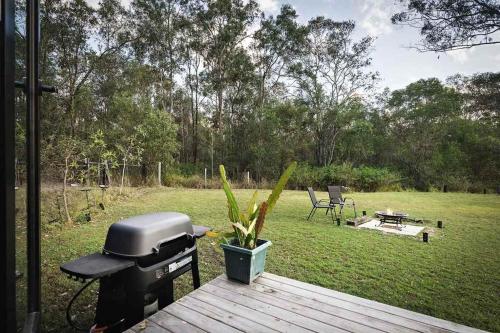 a grill sitting on a deck with a yard at The Mini Chalet by Tiny Away in Bromfleet