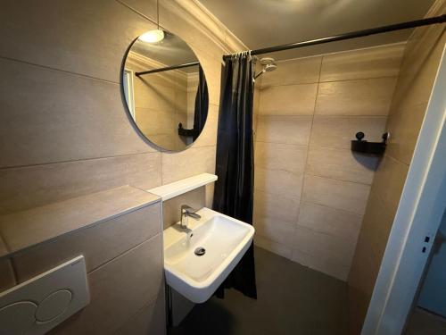 a bathroom with a sink and a mirror at 5 persoons vakantiewoning Robbenoort 50 Lauwersoog in Lauwersoog
