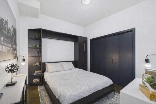 a bedroom with a bed and a black cabinet at Modern Beltline Escape Sky-High Views DT Views in Calgary