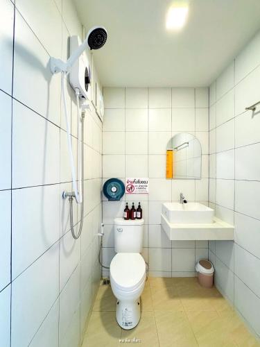 a bathroom with a toilet and a sink at ชิลล์ แคมป์ ชะอม in Ban Bung Mai