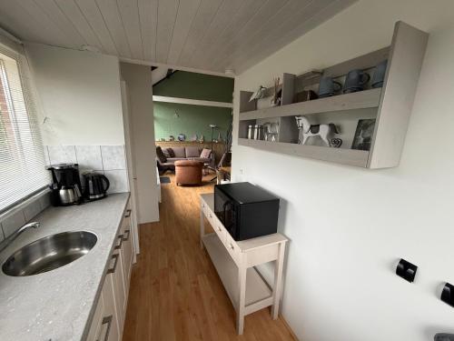 a kitchen with a sink and a tv on a counter at 5 persoons vakantiewoning Robbenoort 50 Lauwersoog in Lauwersoog