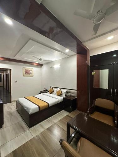 a hotel room with a bed and a desk and a table at Staykart Lotus in Bhilwara