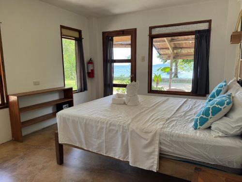a bedroom with a bed with a teddy bear on it at Malinao Beachfront Studio, Starlink, Solar in General Luna