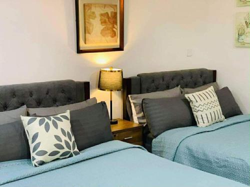 a bedroom with two beds and a couch at EA Staycation in Baguio
