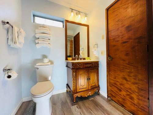 a bathroom with a toilet and a sink and a mirror at Curly Redwood Lodge in Crescent City