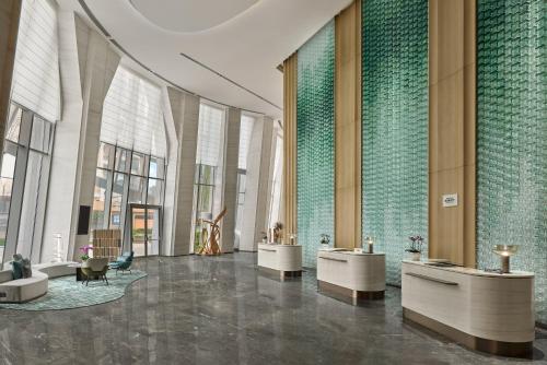a lobby of a building with tables and windows at Courtyard by Marriott Yibin in Yibin