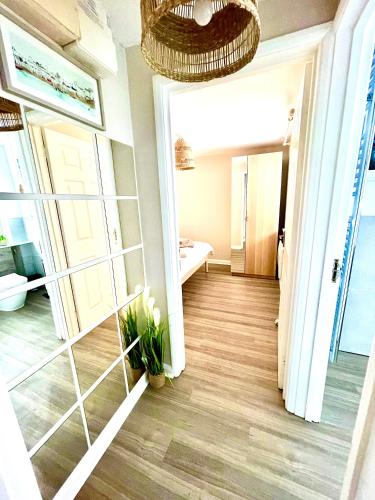 a room with a hallway with a mirror and a room with a sink at Harbour Hideaway, Porthleven in Porthleven