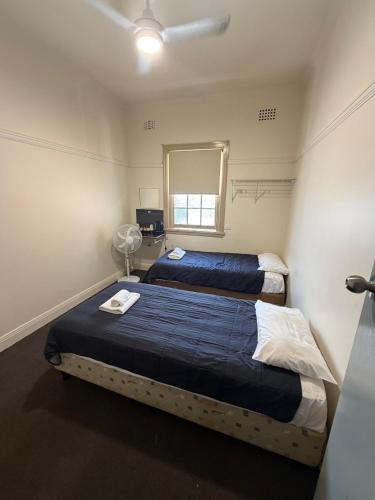 a bedroom with two beds and a mirror at Coffs Harbour Hotel in Coffs Harbour