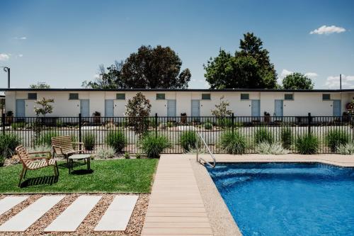 a building with a swimming pool in front of a building at The Cudgee at Mudgee in Mudgee