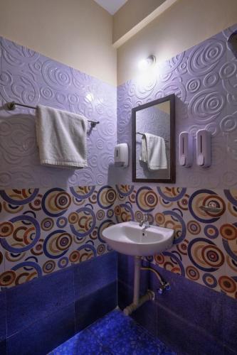 a bathroom with a sink and a mirror at Hotel Padma in Morjim