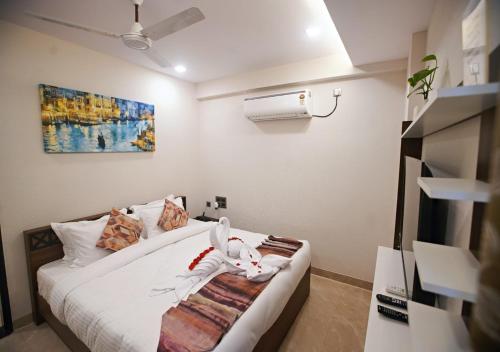 a bedroom with a bed with a towel on it at Suncrisp Studio Rooms in Pedda Waltair