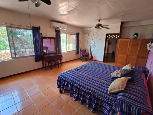 a bedroom with a bed with a blue comforter at Casa Blanca Zipolite, Dream House in Zipolite