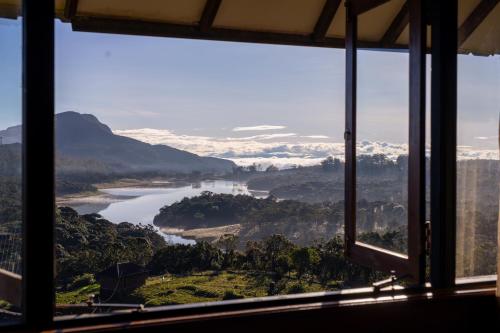 a view of a river from a window at Amansara Bungalow - Panoramic Lake View Villa, Nuwara Eliya in Nuwara Eliya