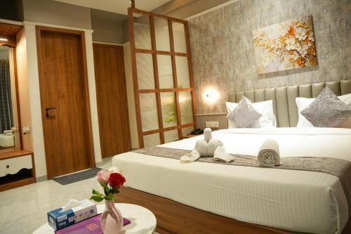 a bedroom with two beds and a table with flowers at Hotel Regency Grand in Shikrapur