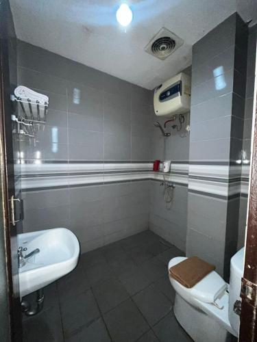 a bathroom with a toilet and a sink at Hotel Alden in Makassar