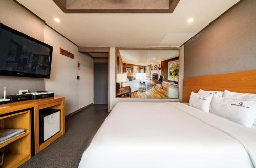 a bedroom with a large bed and a television at Ocean View Haute Hotel in Busan