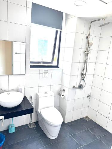 a white bathroom with a toilet and a sink at Chamber Haven KL in Kuala Lumpur
