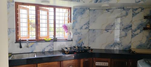 a kitchen with blue and white marble walls and a sink at Temple House in Trivandrum