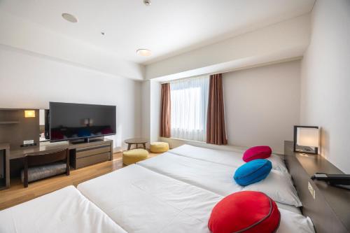 a bedroom with a large white bed with red and blue pillows at Tokyo Bay Ariake Washington Hotel in Tokyo