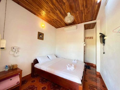 a small bed in a room with a wooden ceiling at phoulisack guesthouse in Ban Sôphoun