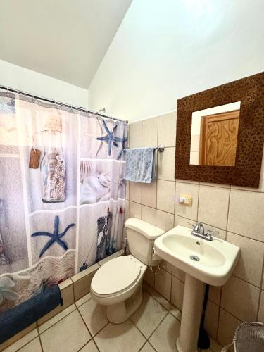 a bathroom with a toilet and a sink at Calm & Palms Second Floor Studio in Coco