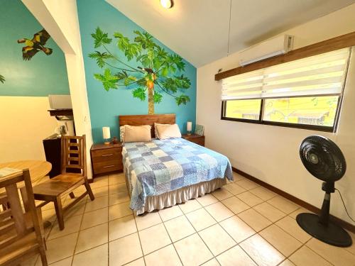 a bedroom with a bed and a window and a fan at Calm & Palms Second Floor Studio in Coco