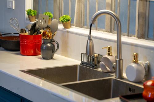 a kitchen sink with utensils in a red container at White House, Billiard, Private Pool, Prime Location in Angeles