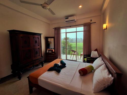 a bedroom with a large bed with a large window at Villa SOORYAALI in Galle