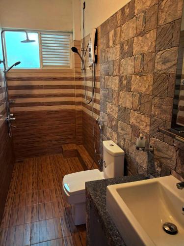 a bathroom with a toilet and a shower and a sink at Villa SOORYAALI in Galle