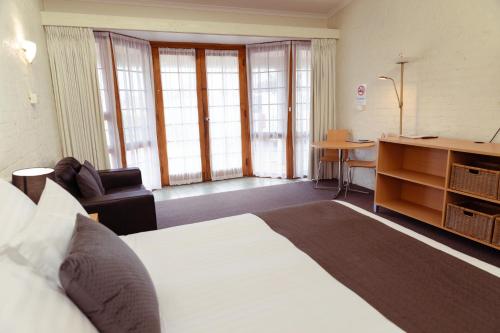 a hotel room with a large bed and a desk at Barclay Motor Inn in Devonport
