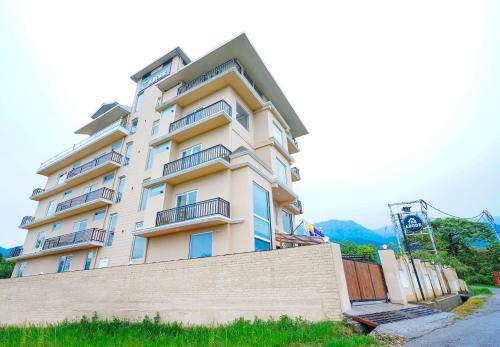 a tall white building with balconies on it at Click Collection The Abode Dharamshala in Dharamshala