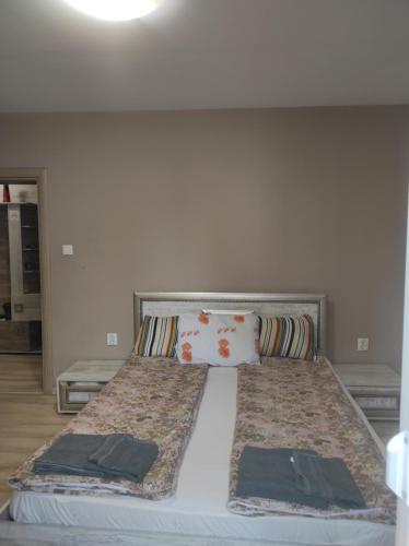 a bed with two pillows on it in a room at Етаж от къща - Нощувки Ками in Pleven